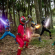 All six members of the Power Rangers: Dino Fury team pose in a forest with their swords out, glowing in each ranger's repsective colors: Pink, blue, red, gold, black, and green.